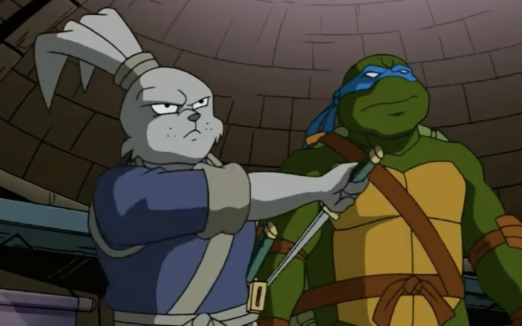 usagi yojimbo the samurai rabbit puts his sword away and stands next to a teenage mutant ninja turtle
