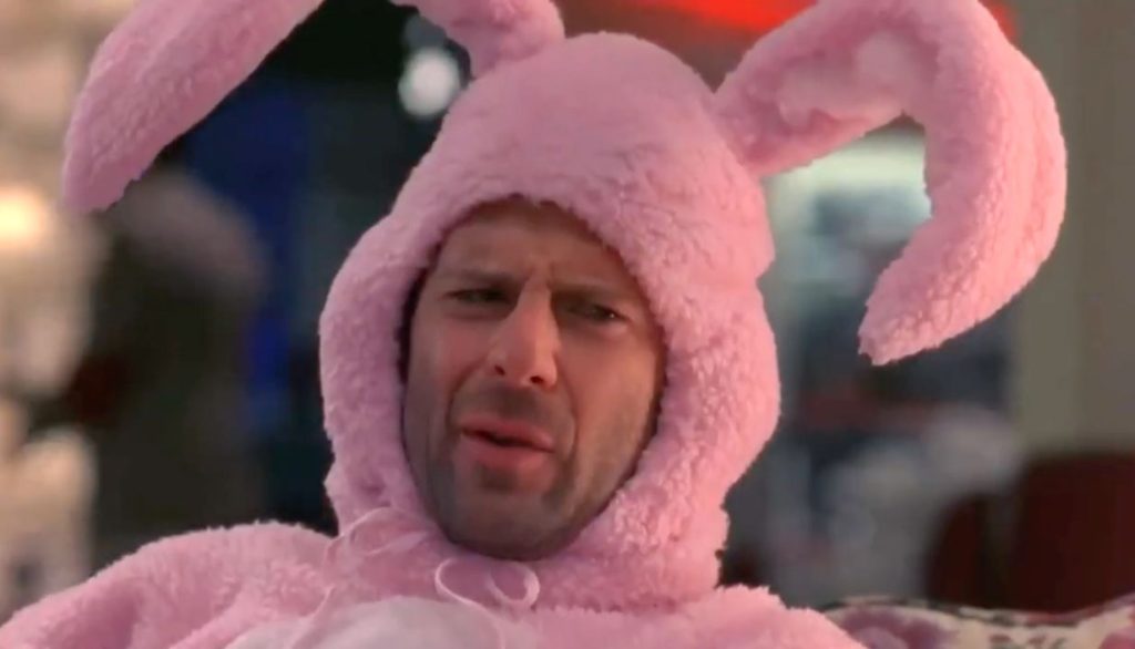 Bruce Willis wears a pink fuzzy bunny costume with big curved ears.